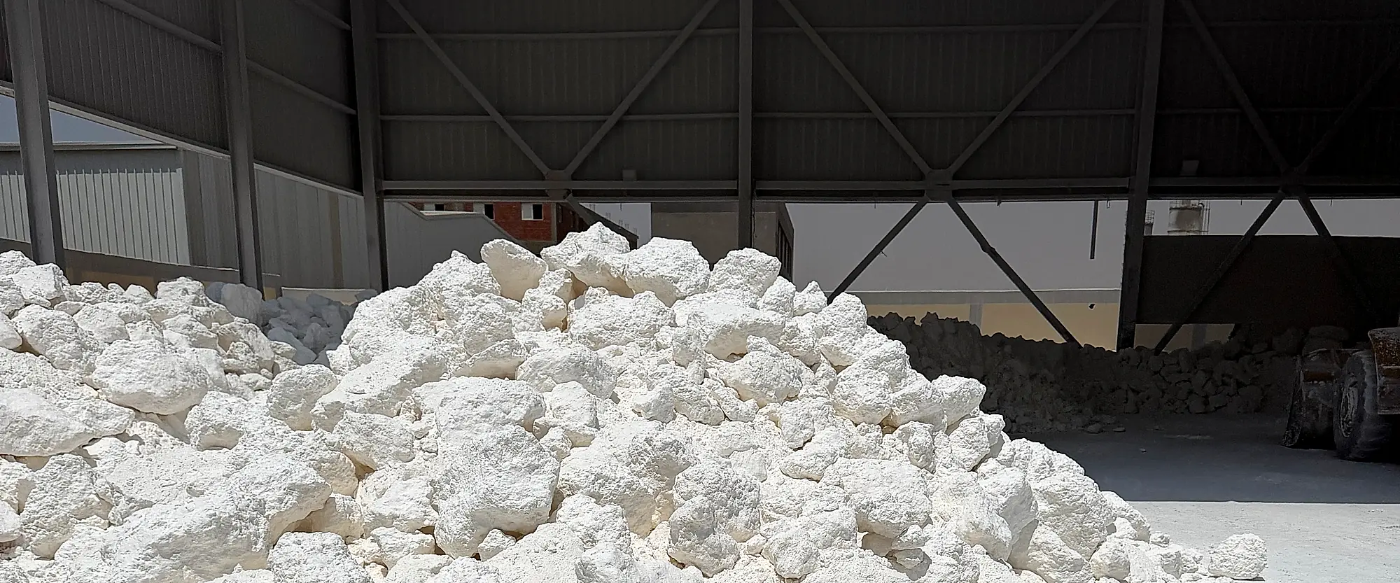 Raw white Egyptian limestone stockpiled in a covered storage bay at our plant